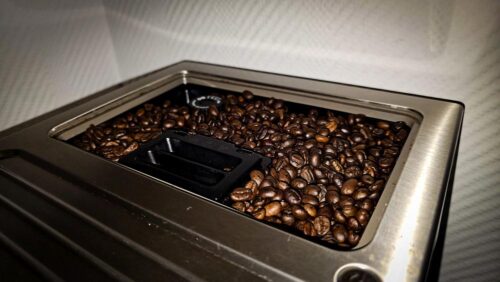Kaffeebohnen im gefüllten Bohnenbehälter eines Vollautomaten, bereit für den ersten Kaffee des Tages.