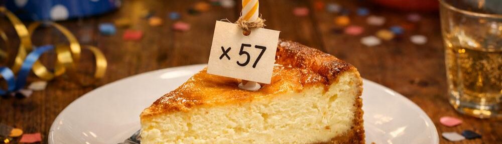 KI-generiertes Bild mit Geburtstagskäsekuchen auf einem festlich dekorierten Tisch.