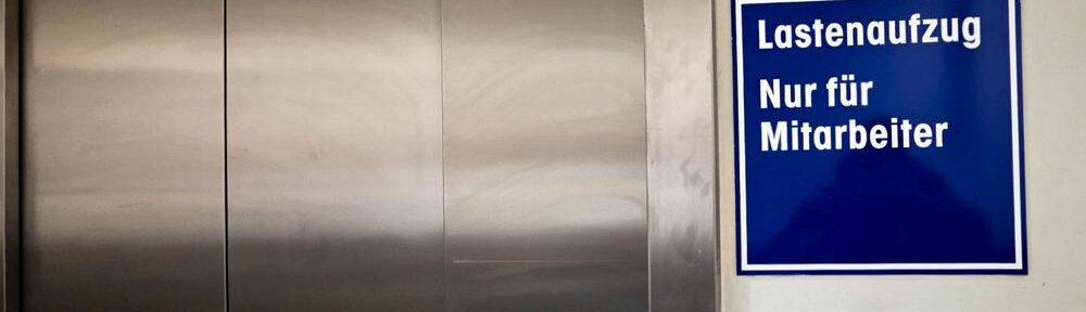 Aufzugtür mit Schild Lastenaufzug nur für Mitarbeiter