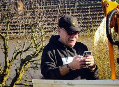 Ungeplanter Schnappschuss im Arbeitsalltag, Blick aufs Smartphone inklusive.