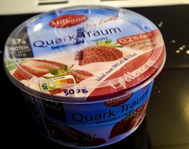 Geschlossener Becher Erdbeerquark auf dem Ceranfeld, äußerlich völlig unauffällig.