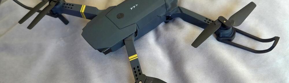 Kleine schwarze Drohne auf hellem Stoff vor dem (vermeintlichen) ersten Testflug.