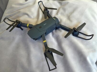 Kleine schwarze Drohne auf hellem Stoff vor dem (vermeintlichen) ersten Testflug.