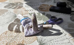 Ein Gartenhandschuh liegt verdreht auf dem Gartentisch und wirkt dabei erstaunlich frech.