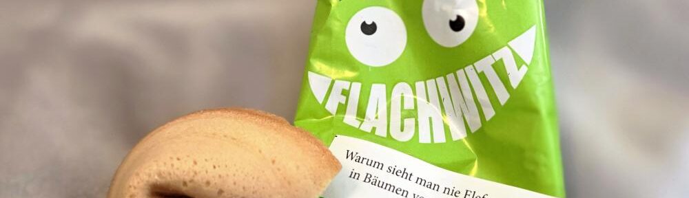 Geöffneter Flachwitz-Keks mit grüner Verpackung und einem Witz über Elefanten, die sich in Bäumen verstecken.