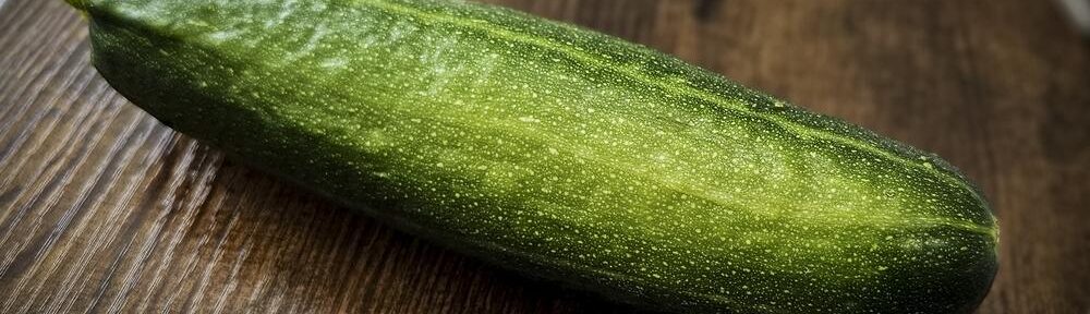 Grüne Zucchini aus eigenem Anbau auf einem runden Holztisch