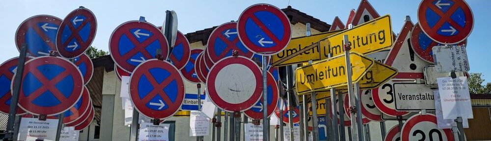Verkehrszeichen für Halteverbote, Tempolimits und Umleitungen stehen dicht gedrängt