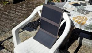 Faltbares 21-Watt-Solarpaneel auf einem Gartenstuhl in der Sonne.