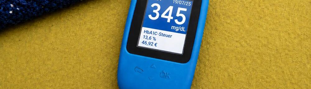 Blutzuckermessgerät mit satirischer HbA1c-Steuer und errechnetem Euro-Betrag. KI-generierte Darstellung auf Basis eines eigenen Fotos.