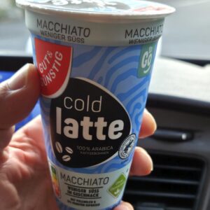Kalter Latte Macchiato aus dem Kühlregal im Auto als Kaffee-Notlösung unterwegs.
